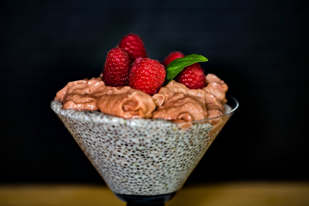 Chia Pudding topped with Raspberry Mousse and garnished with fresh raspberries with a sprig of basil