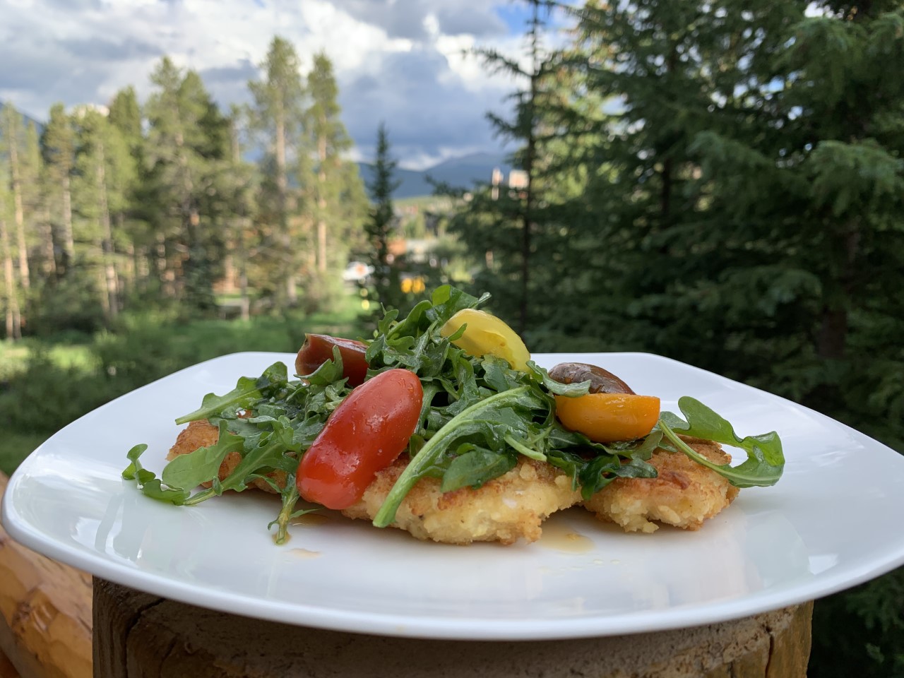 Chicken Milanese is a thinly coated chicken breast sautéed then topped with an arugula and tomato salad