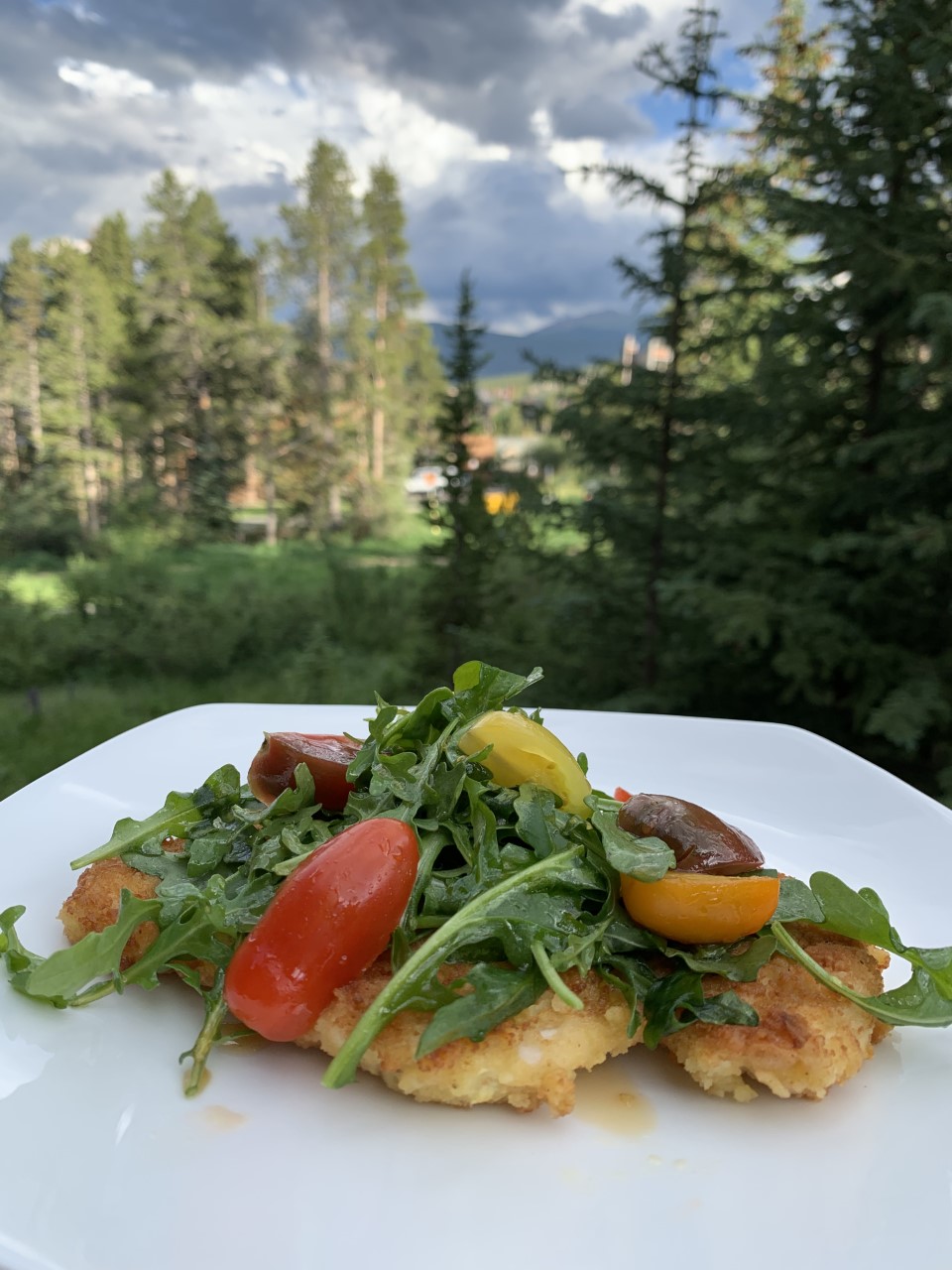 Thinly coated chicken breasts topped with an arugula & tomato salad