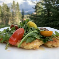 Chicken Milanese is a thinly coated chicken breast sauteed then topped with an arugula and tomato salad